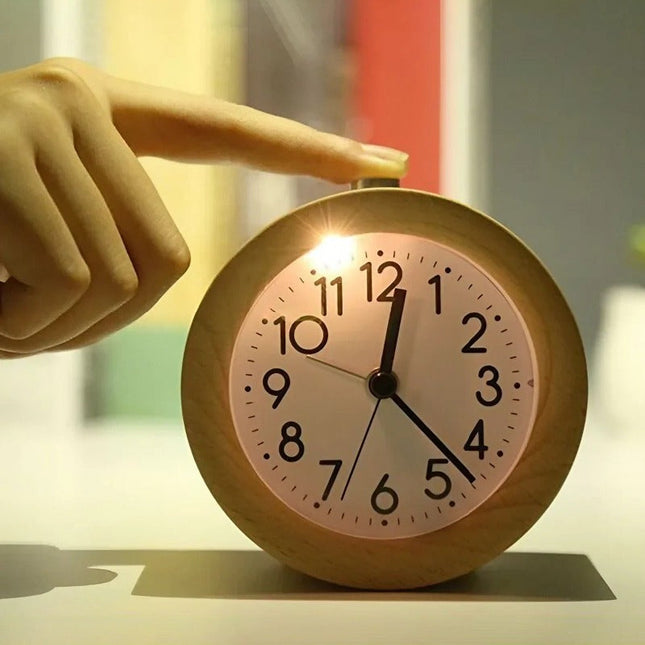 Rundt analogt vækkeur i mørkt træ